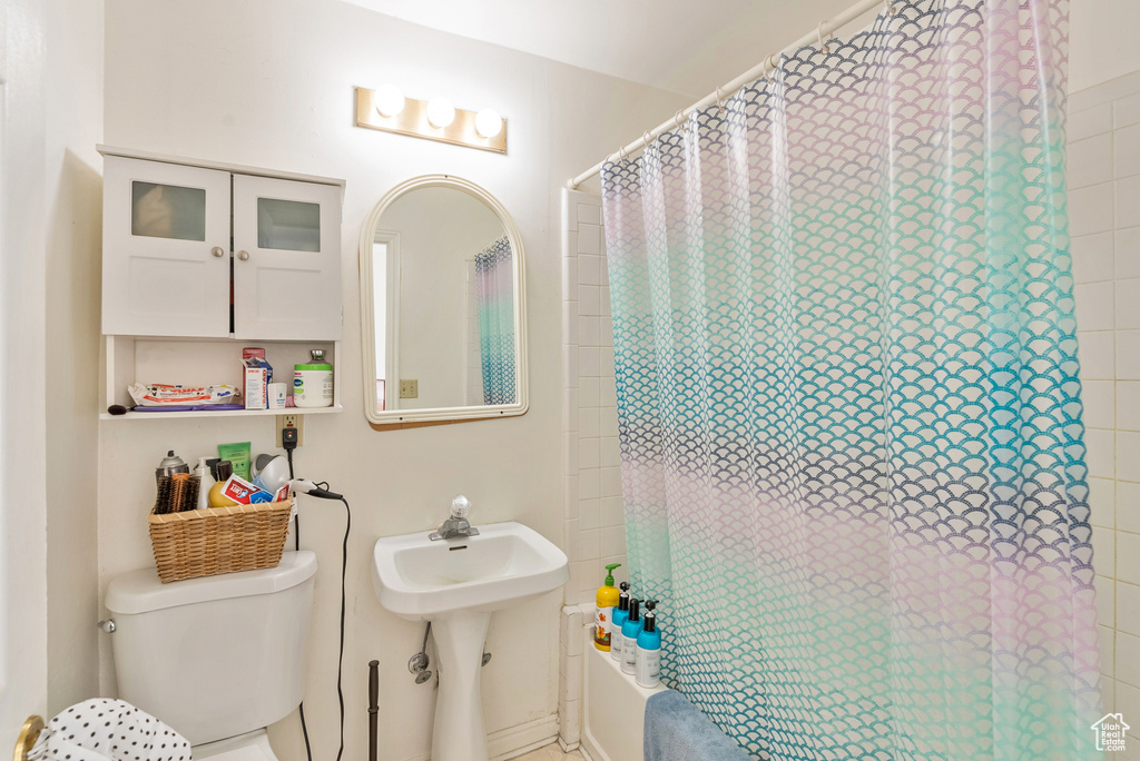 Full bathroom with sink, shower / tub combo, and toilet