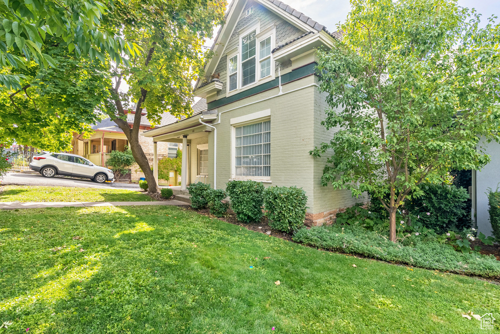 View of side of property featuring a lawn