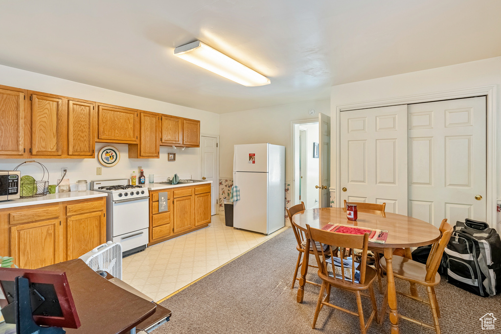 Kitchen featuring white appliances and sink