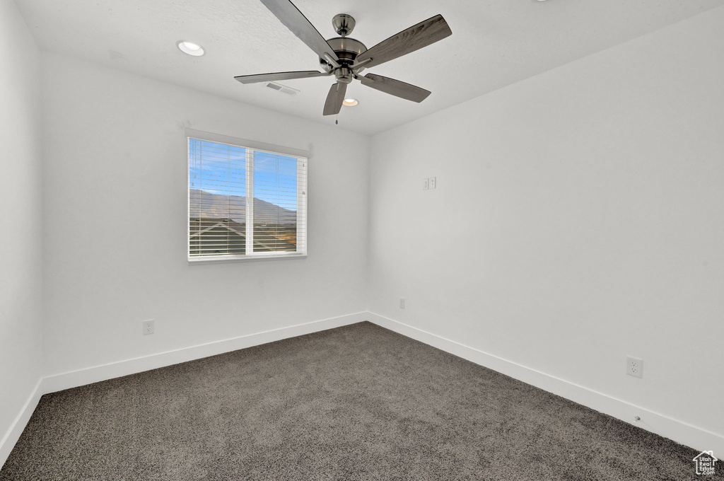 Carpeted empty room with ceiling fan