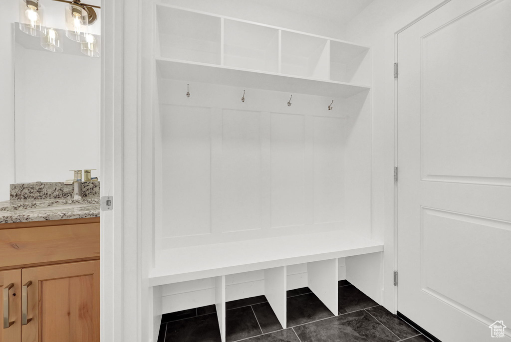 Mudroom featuring dark tile patterned floors and sink