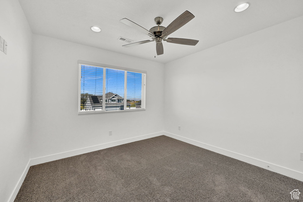 Spare room with ceiling fan and carpet floors