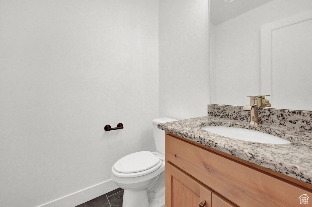 Bathroom featuring tile patterned flooring, vanity, and toilet