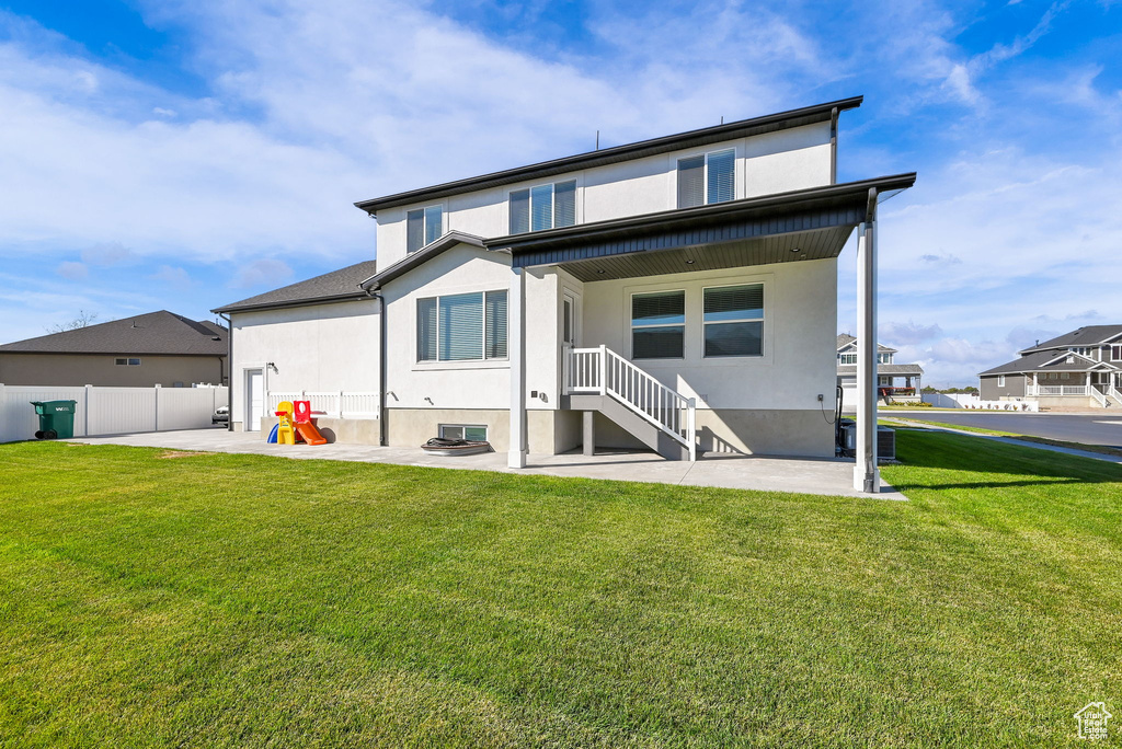 Rear view of property featuring a patio and a yard