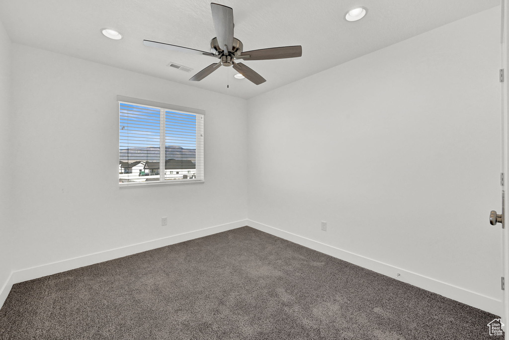 Carpeted spare room with ceiling fan