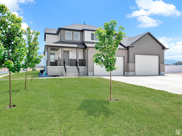 View of front of home with a front lawn, a porch, and a garage