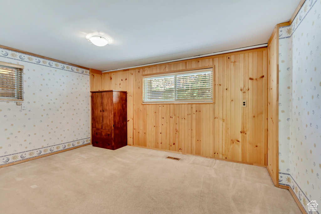 Carpeted empty room with wood walls