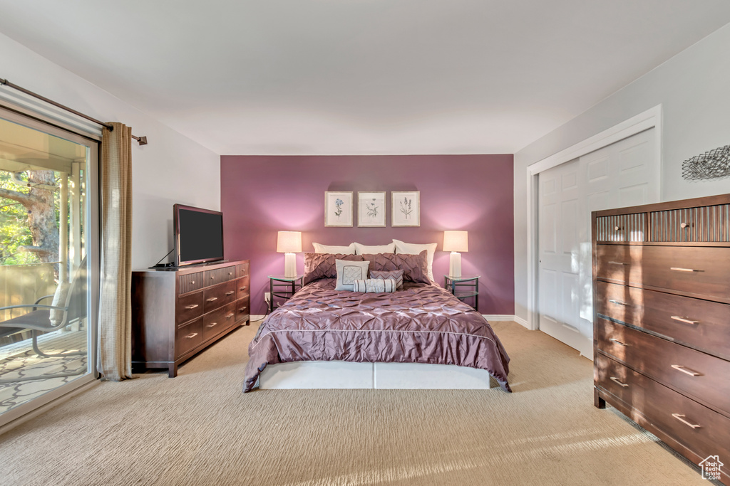 Bedroom with light colored carpet, a closet, and access to exterior