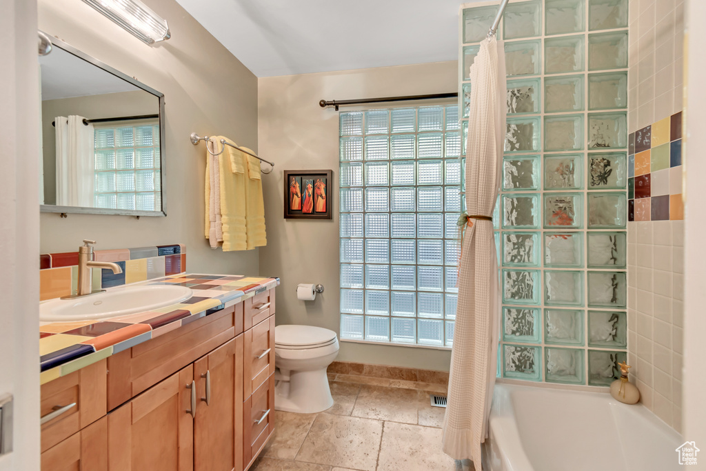 Full bathroom with shower / tub combo with curtain, vanity, and toilet