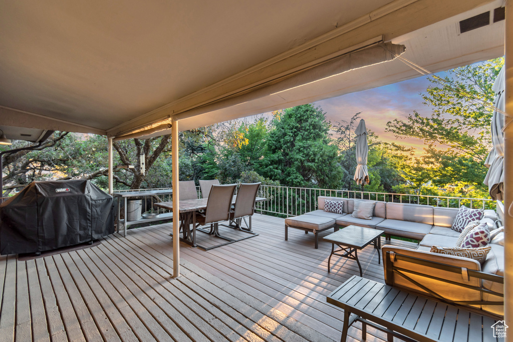 Deck at dusk with area for grilling and an outdoor living space