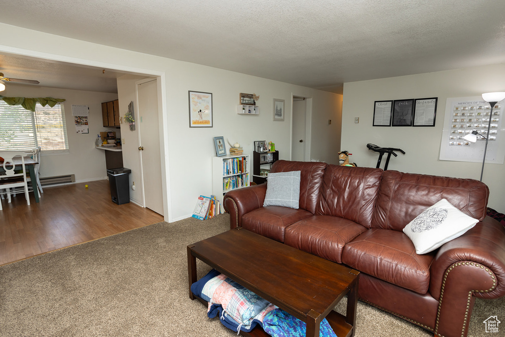 Living room with ceiling fan, hardwood / wood-style floors, and a textured ceiling