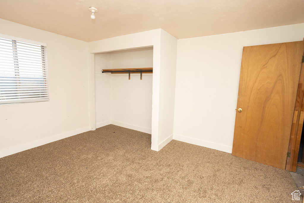 Unfurnished bedroom featuring carpet floors and a closet