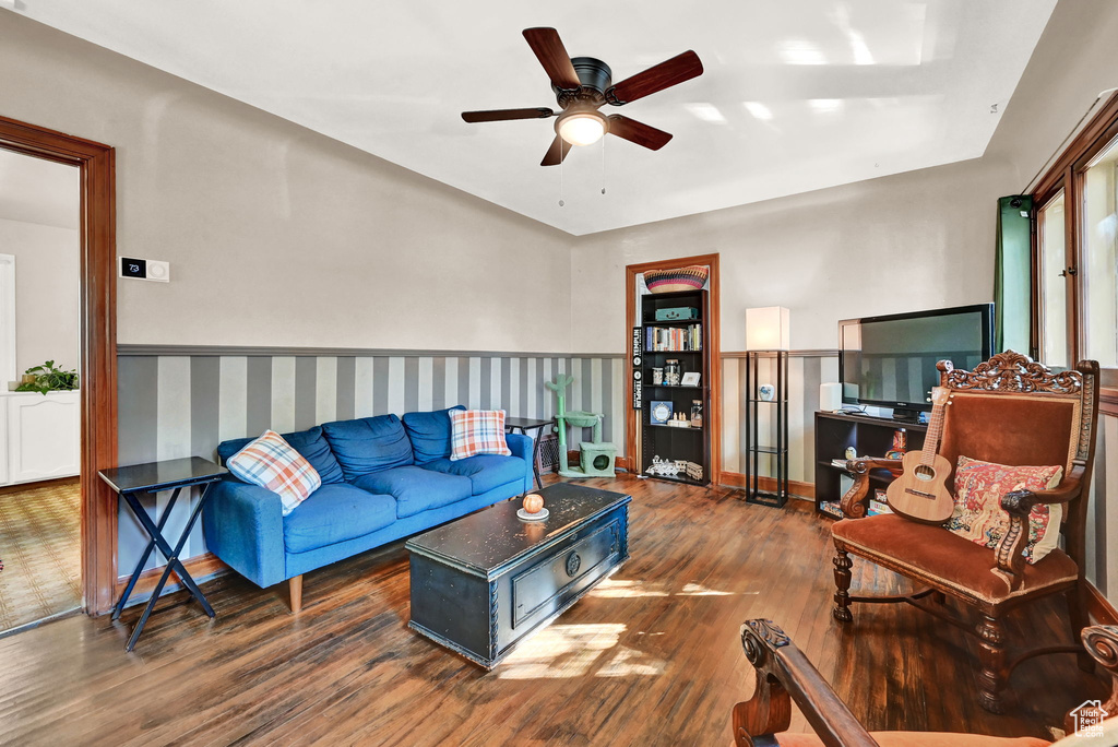 Living room with ceiling fan and dark hardwood / wood-style flooring