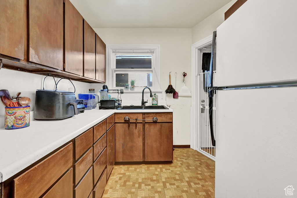 Kitchen featuring white refrigerator and sink