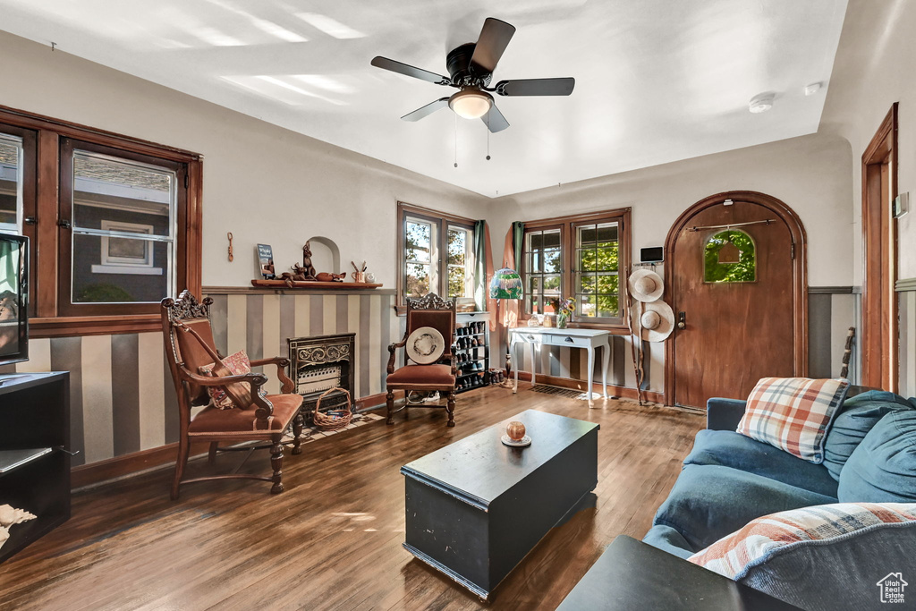 Living room featuring ceiling fan, a fireplace, and dark hardwood / wood-style flooring