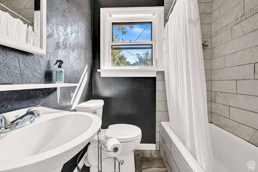 Full bathroom featuring sink, shower / tub combo, and toilet