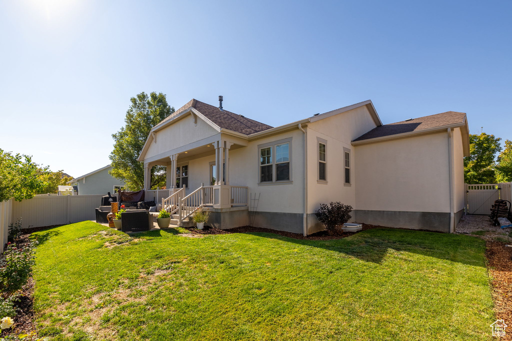 Rear view of house featuring a lawn