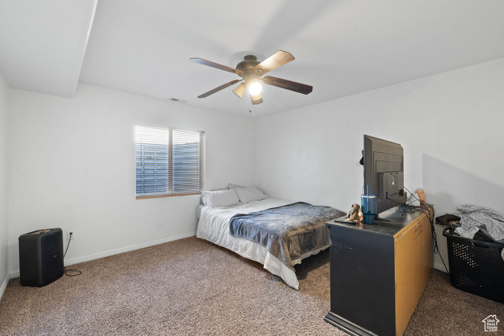 Bedroom with dark colored carpet and ceiling fan