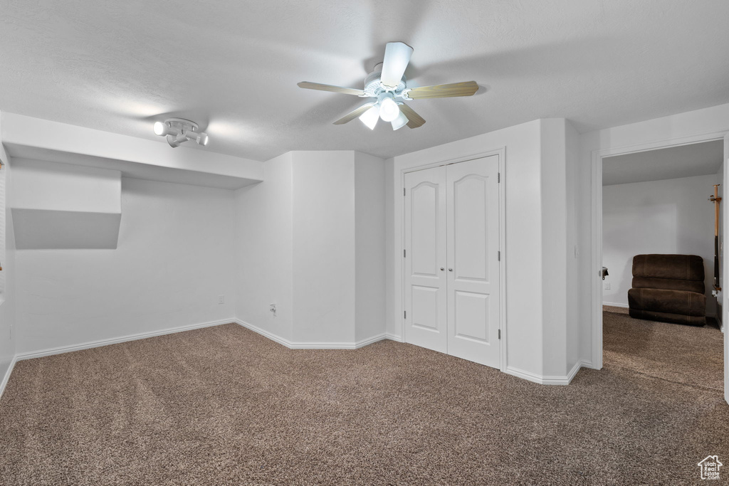 Basement with carpet flooring and ceiling fan