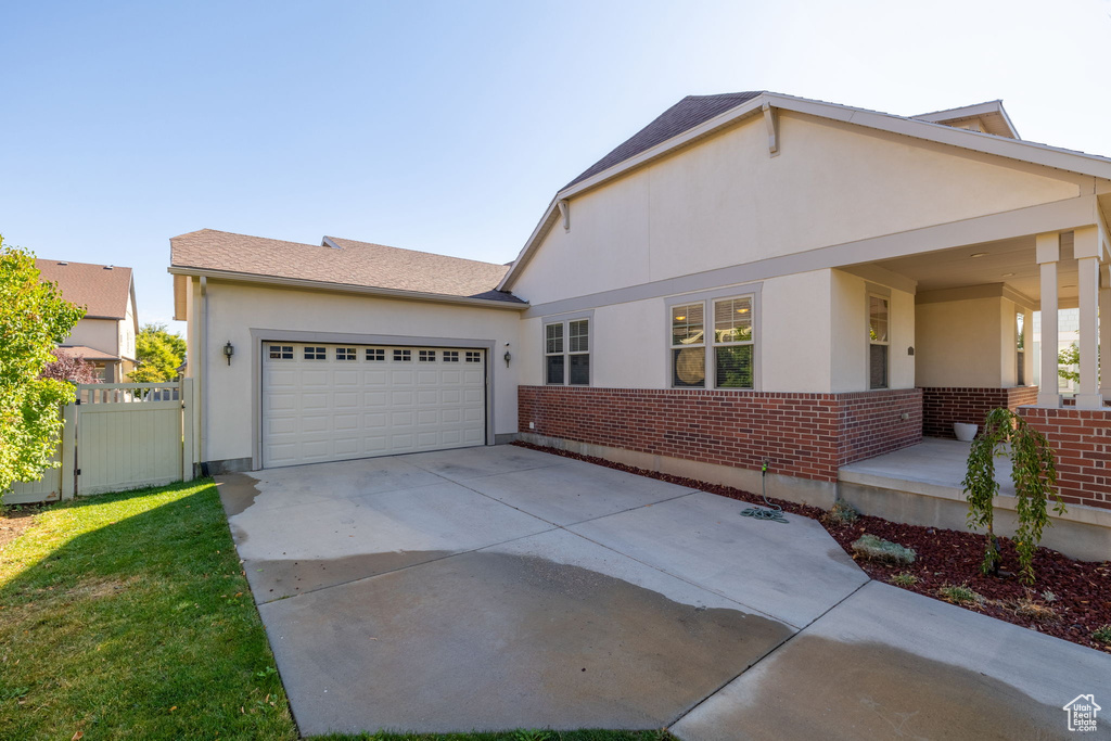 View of front facade featuring a garage and a front lawn