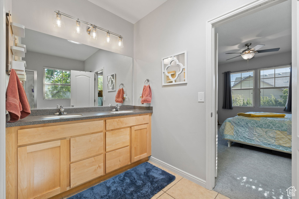 Bathroom featuring ceiling fan, tile patterned floors, a wealth of natural light, and vanity