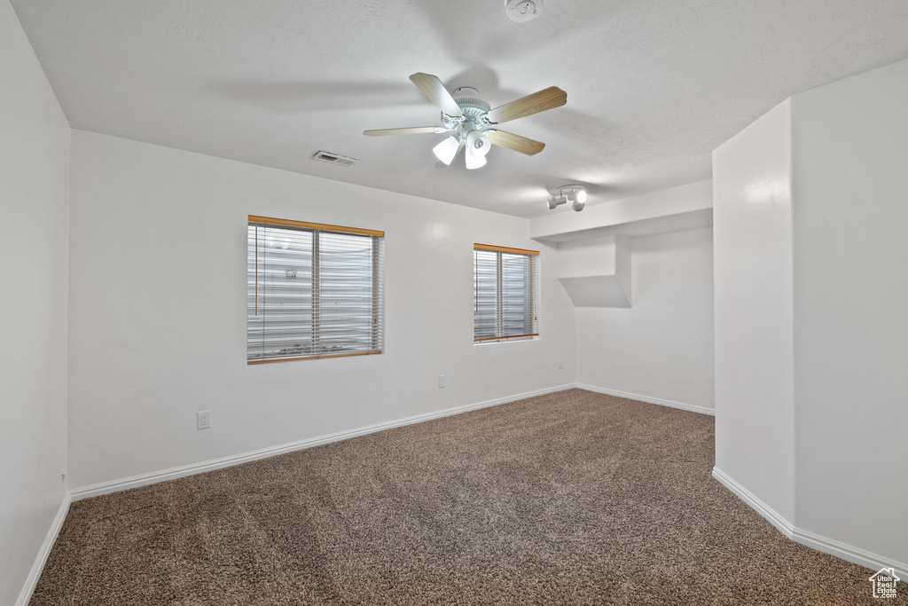 Unfurnished room featuring ceiling fan and carpet flooring