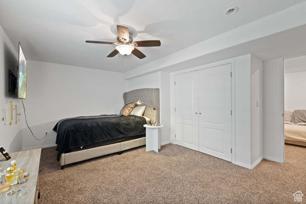 Bedroom with a closet, carpet, and ceiling fan