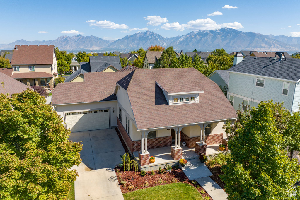 View of front of house featuring a mountain view, covered porch, and a garage