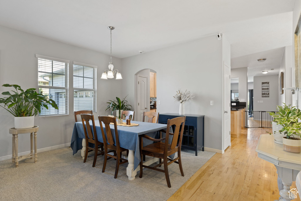 Dining space featuring a notable chandelier and light wood-type flooring