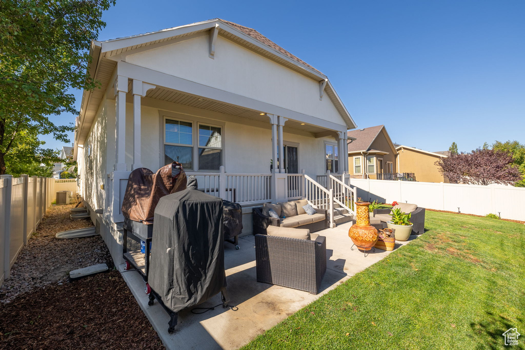 Back of property featuring an outdoor living space, a porch, a lawn, and a patio area