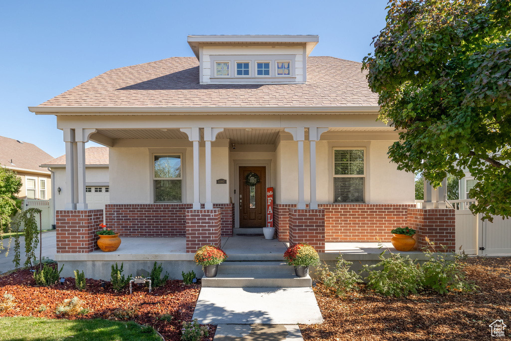 View of front facade with covered porch and a garage