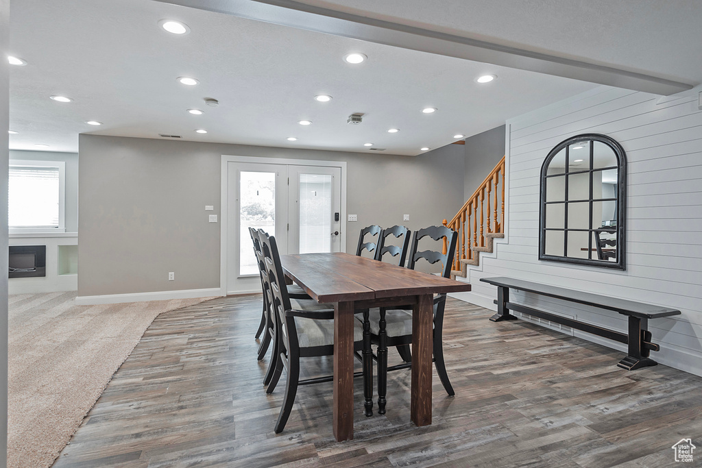 Dining area featuring plenty of natural light, wood walls, and hardwood / wood-style floors