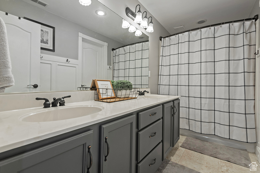 Bathroom with vanity, tile patterned flooring, and a shower with shower curtain