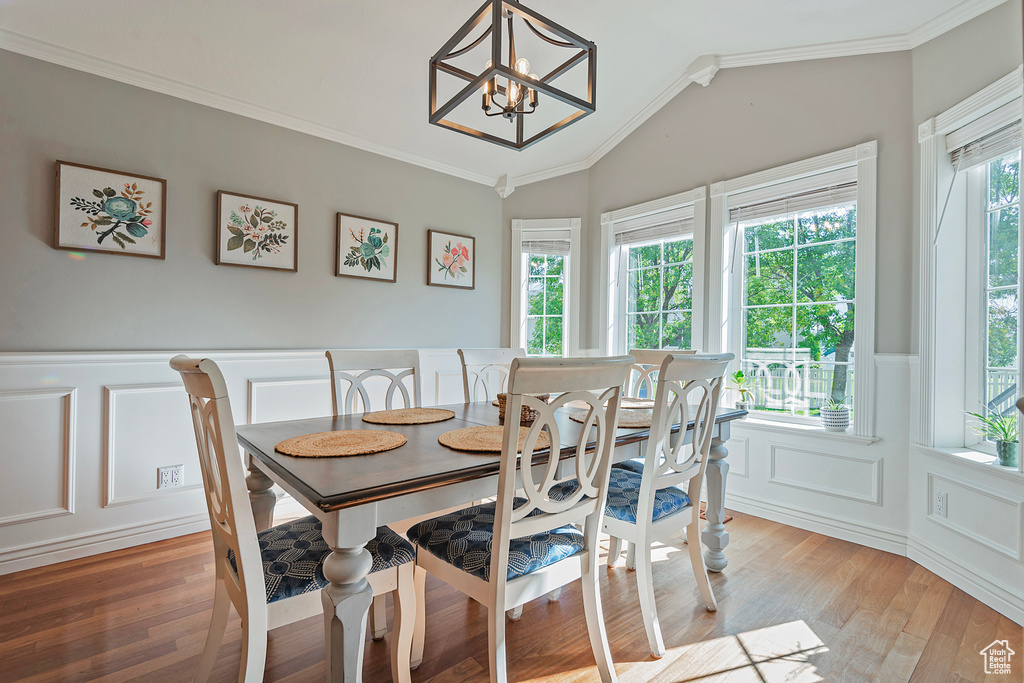 Dining area featuring crown molding, plenty of natural light, hardwood / wood-style floors, and a chandelier