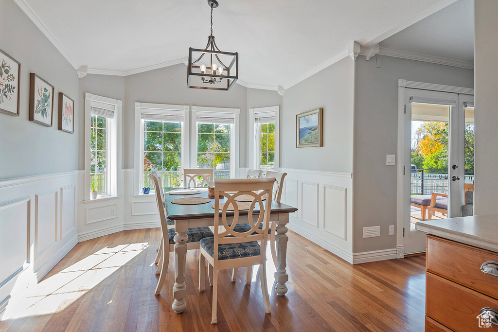 Dining room with a healthy amount of sunlight, crown molding, and light hardwood / wood-style flooring