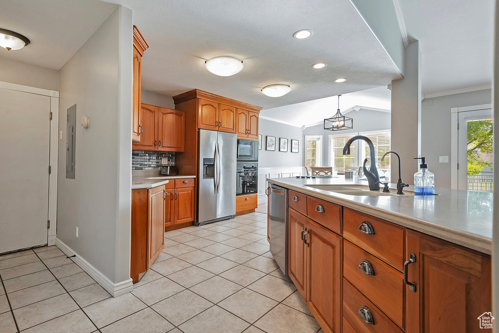 Kitchen with lofted ceiling, plenty of natural light, appliances with stainless steel finishes, and sink