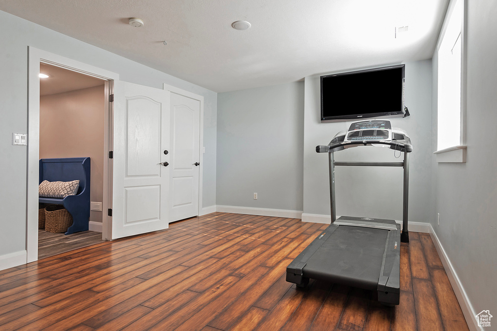 Exercise room featuring dark wood-type flooring