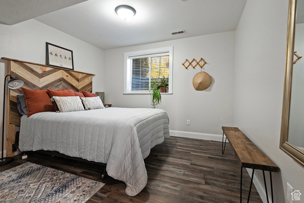 Bedroom with dark hardwood / wood-style floors