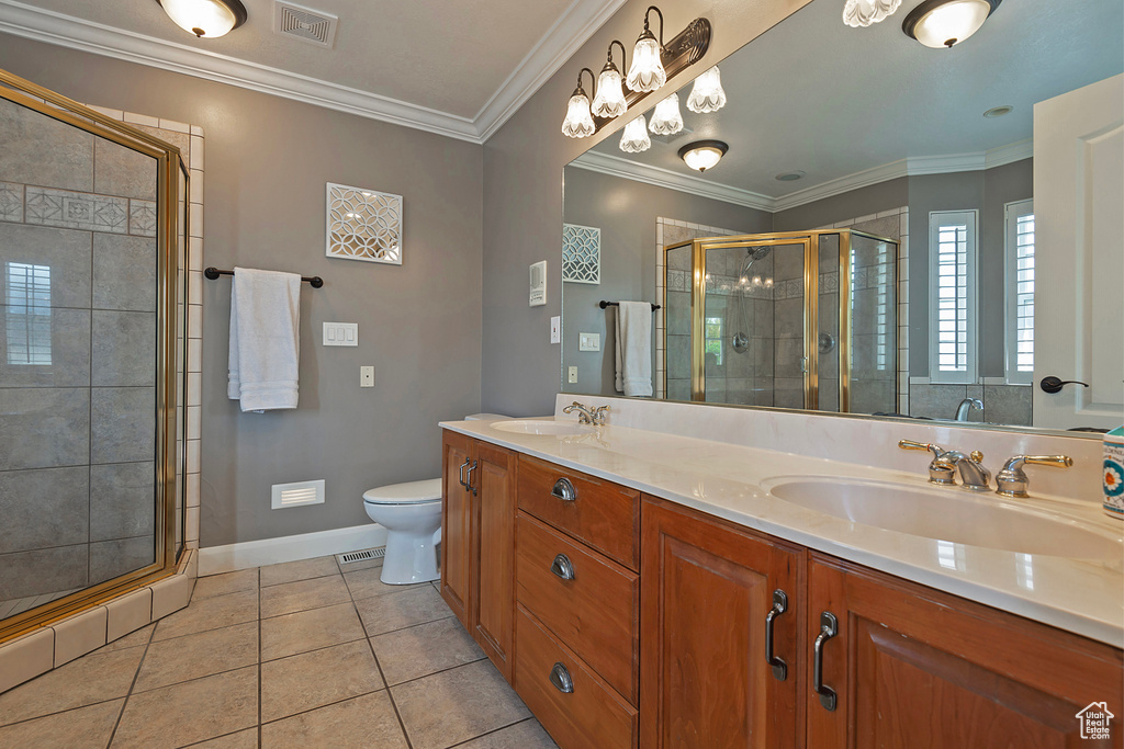 Bathroom featuring vanity, toilet, walk in shower, crown molding, and tile patterned flooring