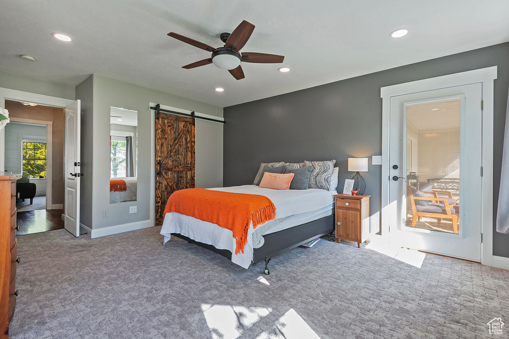 Bedroom featuring ceiling fan, carpet flooring, and a barn door