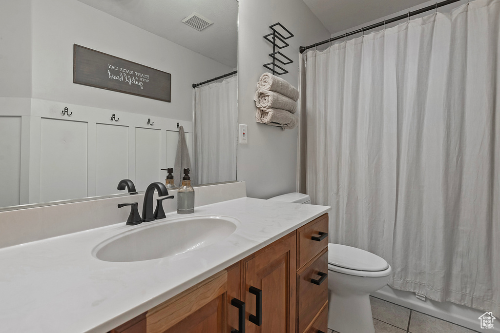 Bathroom with walk in shower, vanity, tile patterned flooring, and toilet