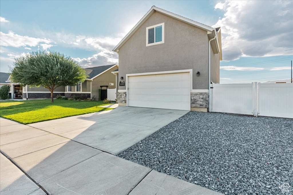 View of home\'s exterior featuring a garage and a lawn