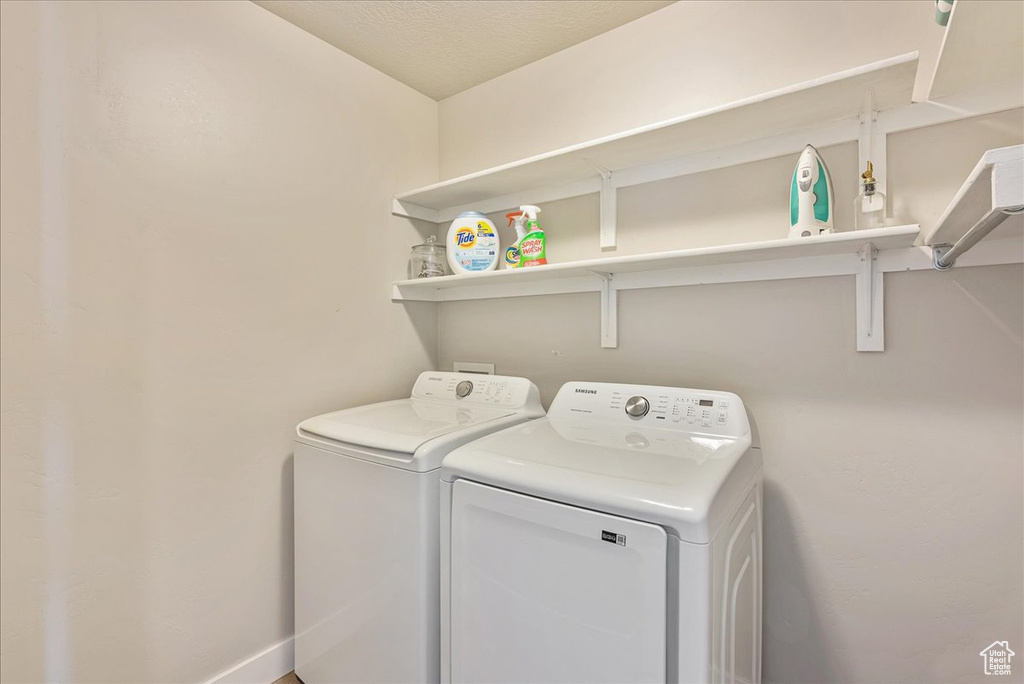 Laundry area with washer and dryer and a textured ceiling