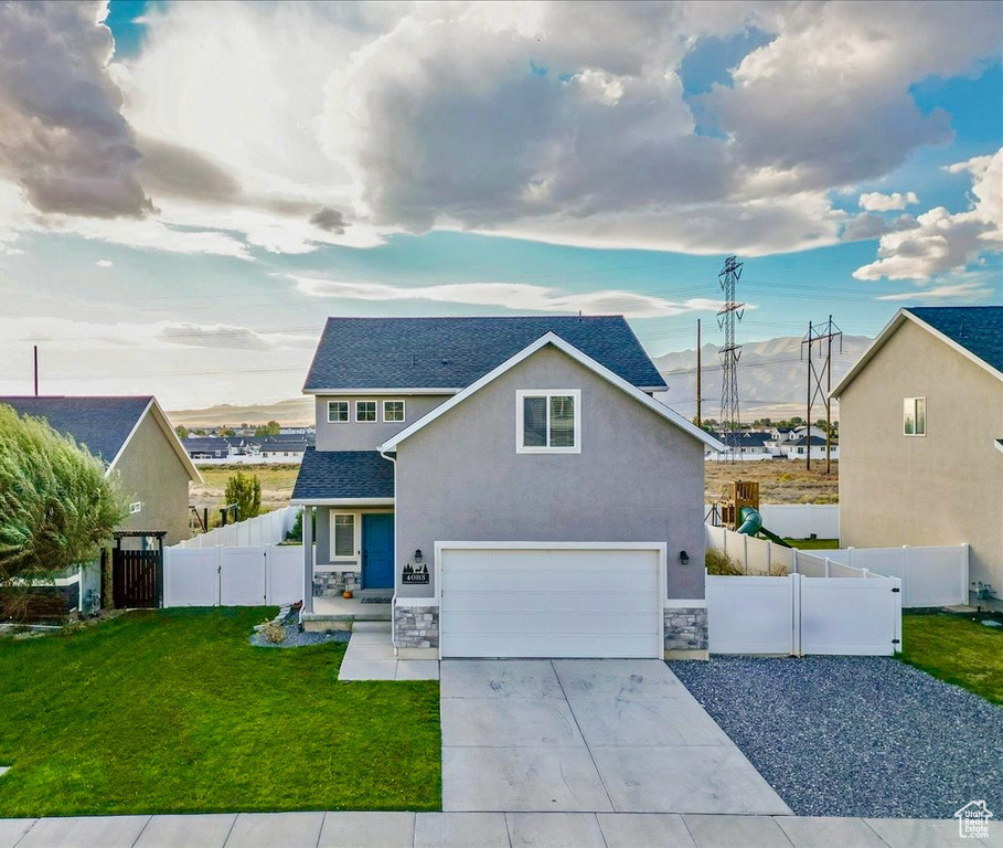 View of front of house featuring a front yard and a garage