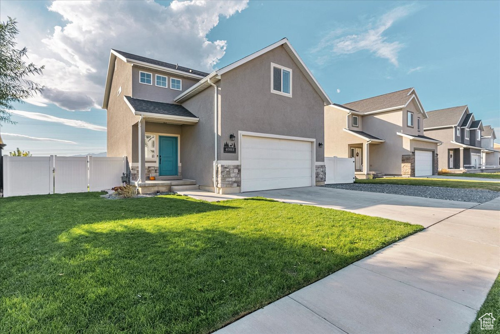 View of front of property featuring a front yard and a garage