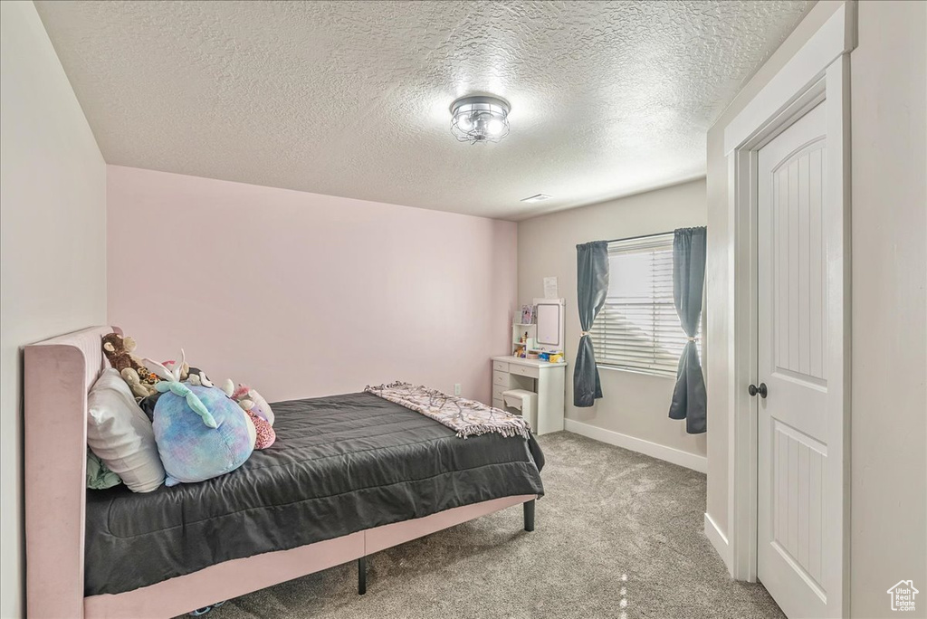 Carpeted bedroom with a textured ceiling