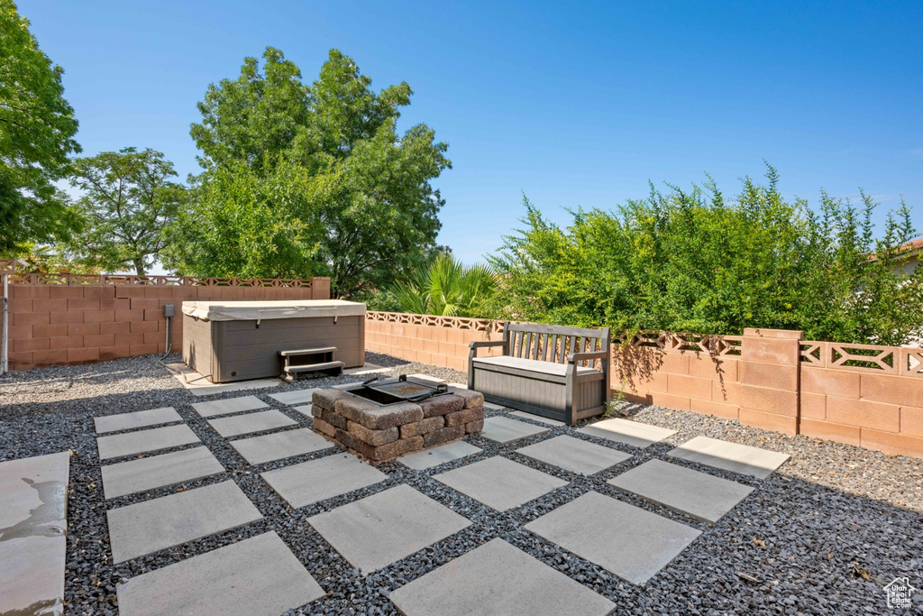 View of patio featuring an outdoor fire pit and a hot tub