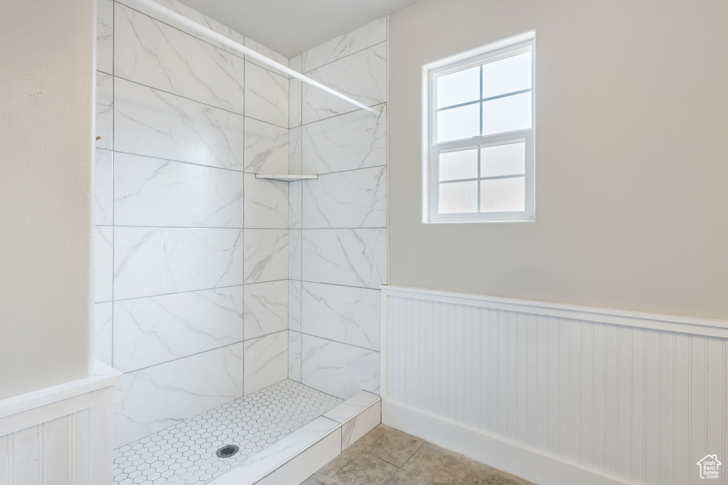 Bathroom with tile patterned flooring and tiled shower