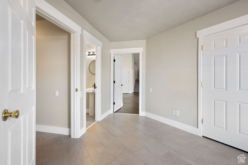 Interior space with ensuite bathroom, light wood-type flooring, and a textured ceiling