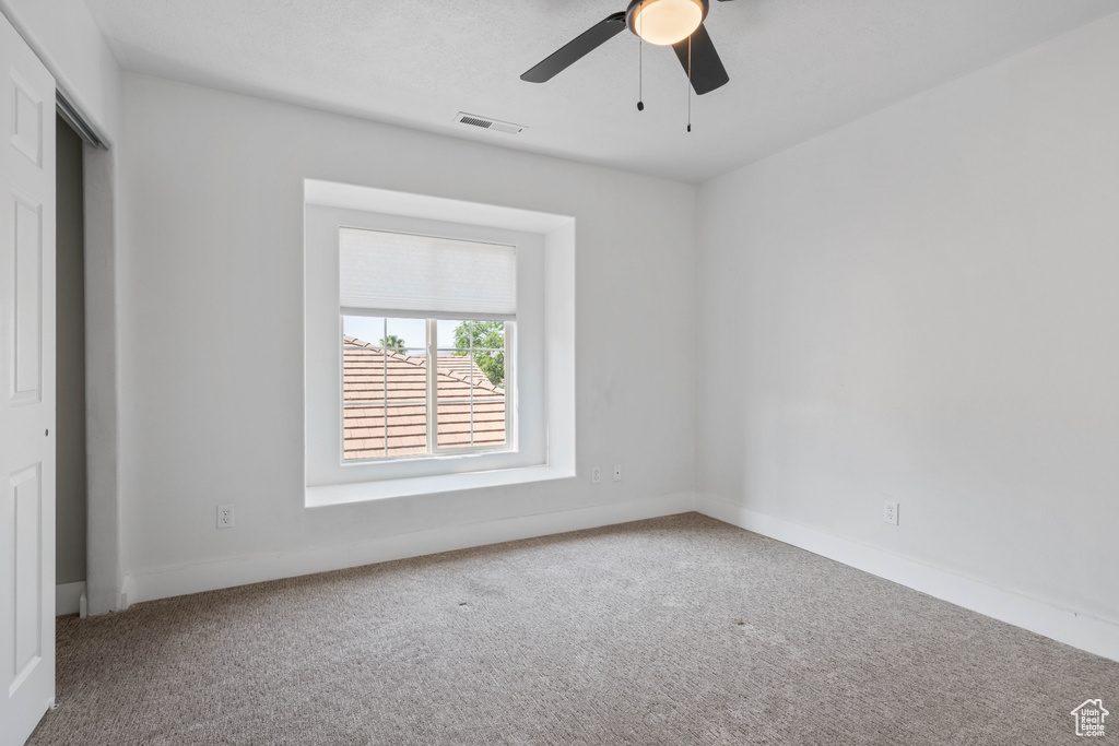 Empty room with ceiling fan and carpet